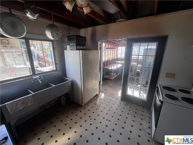 kitchen featuring light floors, a wealth of natural light, and electric stove
