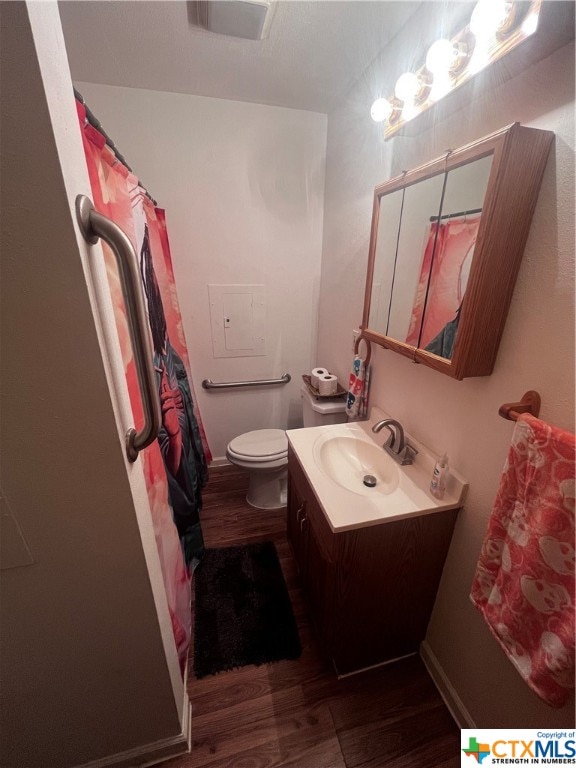 bathroom with hardwood / wood-style flooring, vanity, and toilet