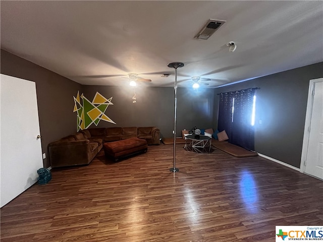 unfurnished living room featuring ceiling fan and dark wood-type flooring