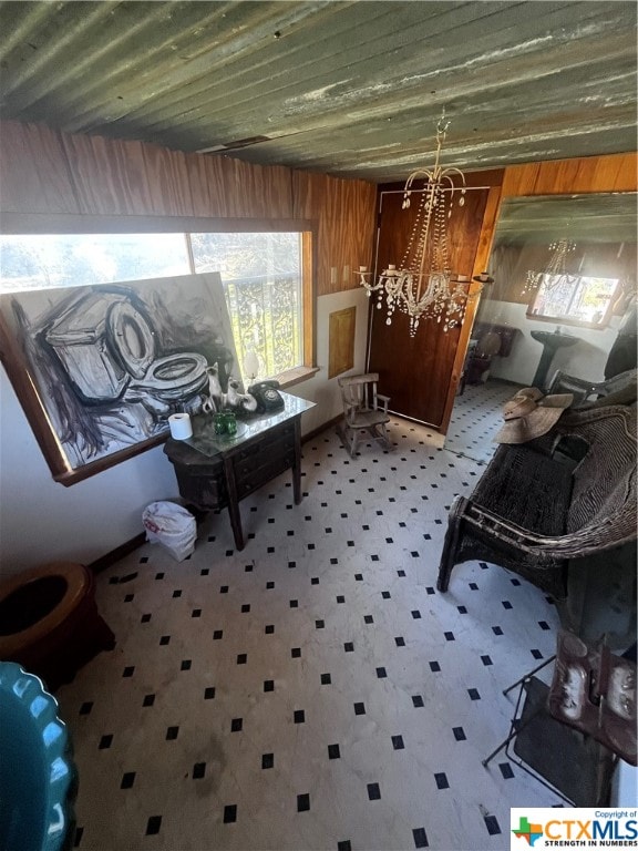 sitting room featuring wood walls and a chandelier