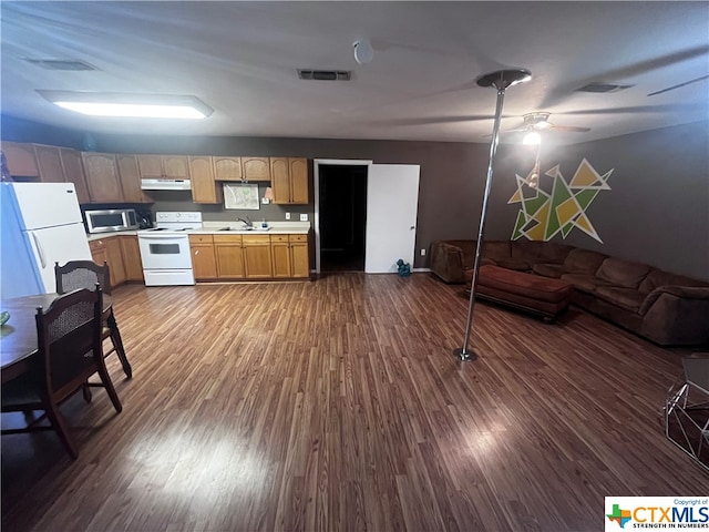 kitchen featuring dark hardwood / wood-style floors, ceiling fan, white appliances, and sink