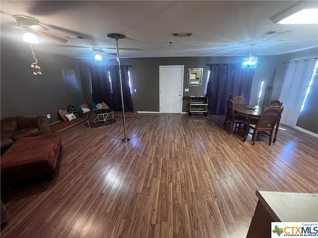 living room featuring ceiling fan and dark wood-type flooring