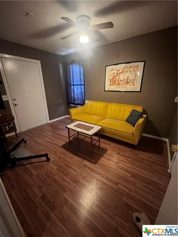 living room with baseboards, a ceiling fan, and wood finished floors