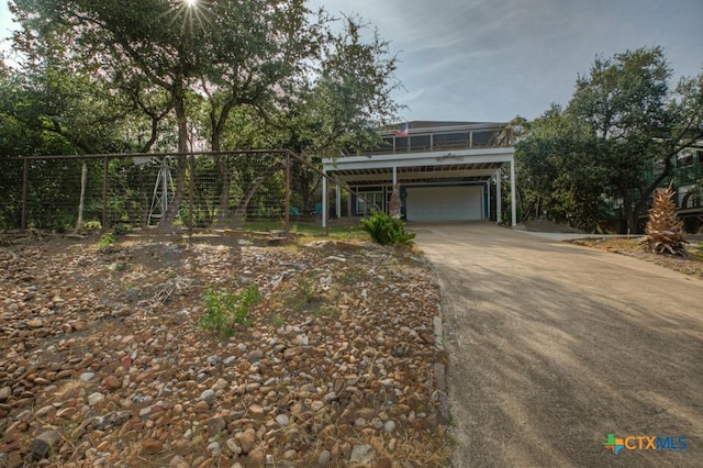 raised beach house featuring an attached garage, stairs, and concrete driveway