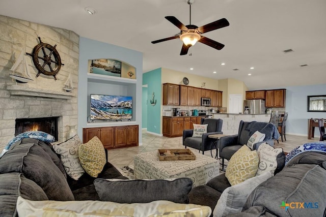 living room with a ceiling fan, a stone fireplace, built in shelves, baseboards, and visible vents