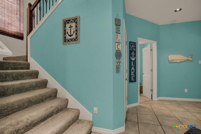stairway featuring baseboards, tile patterned flooring, and recessed lighting