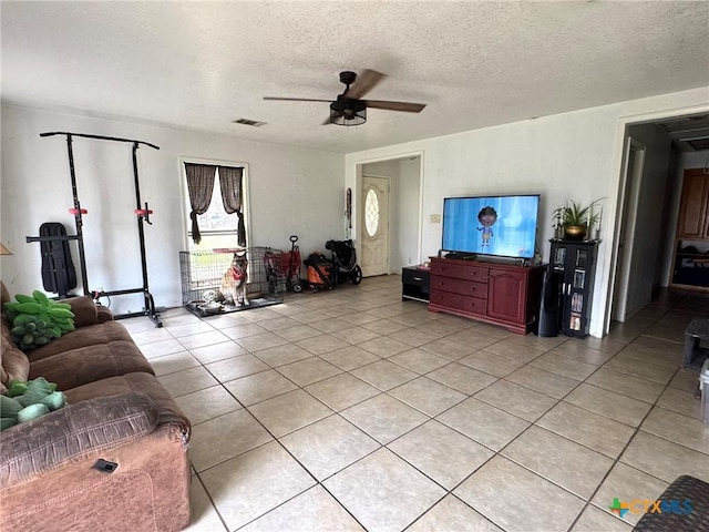 living room featuring light tile patterned flooring, a textured ceiling, and ceiling fan