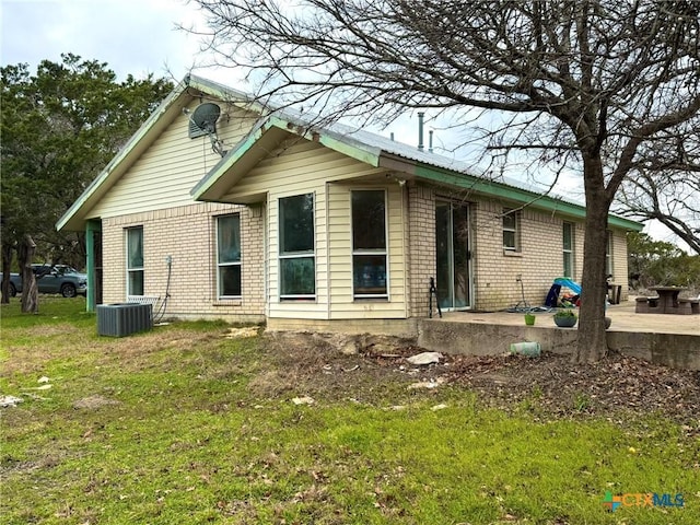 back of house with a lawn and a patio