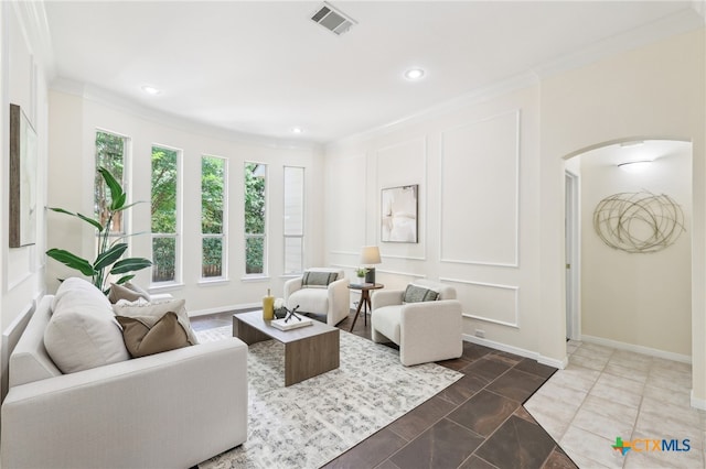 living room featuring arched walkways, ornamental molding, recessed lighting, and baseboards