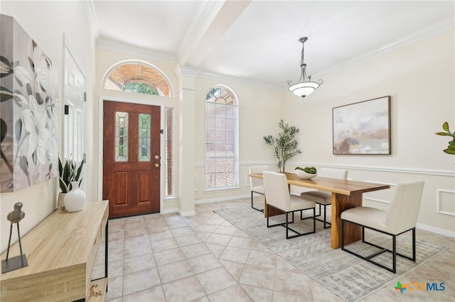foyer with crown molding and light tile patterned floors