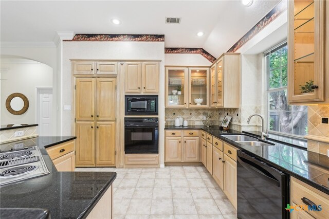 kitchen with black appliances, a sink, light brown cabinetry, arched walkways, and tasteful backsplash