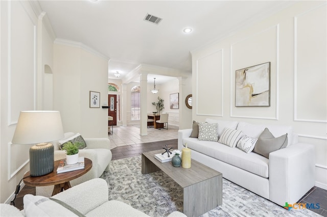 living room featuring arched walkways, crown molding, recessed lighting, wood finished floors, and baseboards