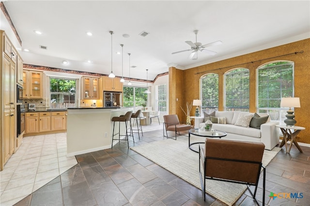 living area featuring ceiling fan, recessed lighting, and stone tile flooring