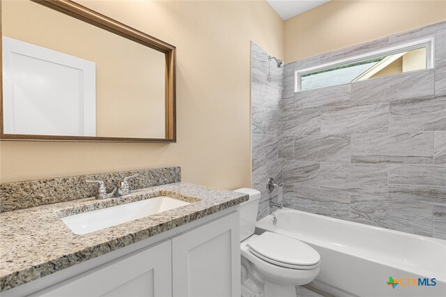 full bathroom with toilet, vanity, and tiled shower / bath