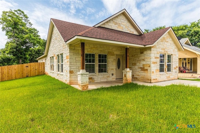 1700 Proctor Ave, Waco, TX 76708 - back of property with a shingled roof, stone siding, and a patio area