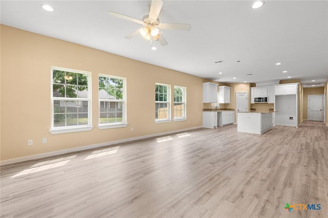 1700 Proctor Ave, Waco, TX 76708 - unfurnished living room with recessed lighting, light wood-style flooring, baseboards, ceiling fan, and a sink