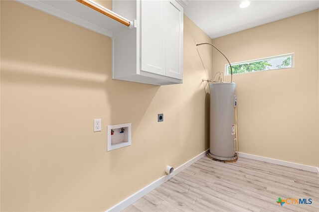 clothes washing area featuring electric water heater, light hardwood / wood-style floors, electric dryer hookup, and cabinets