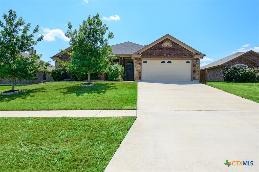 view of front of home with a garage and a front lawn