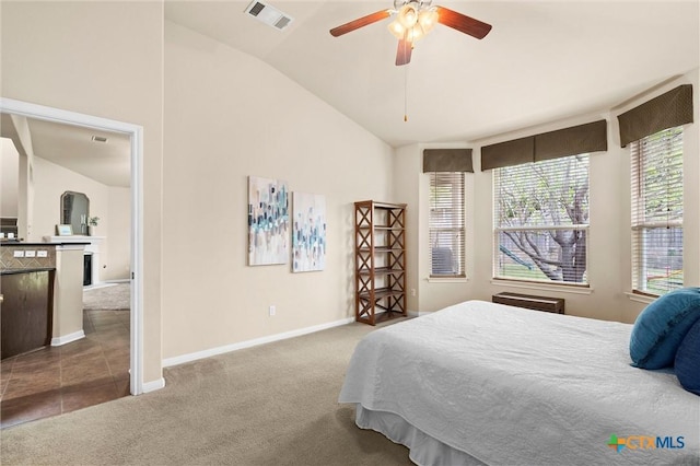 bedroom featuring carpet, vaulted ceiling, baseboards, and a ceiling fan