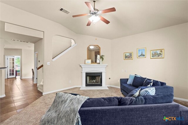 tiled living room with a ceiling fan, baseboards, and a fireplace with raised hearth