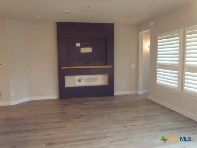 791 Hazy Hills Loop, Dripping Springs, TX 78620 - unfurnished living room featuring wood finished floors and baseboards