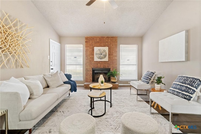 living room featuring a fireplace, a textured ceiling, and plenty of natural light