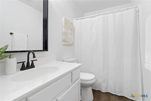 bathroom with vanity, hardwood / wood-style floors, toilet, and a textured ceiling