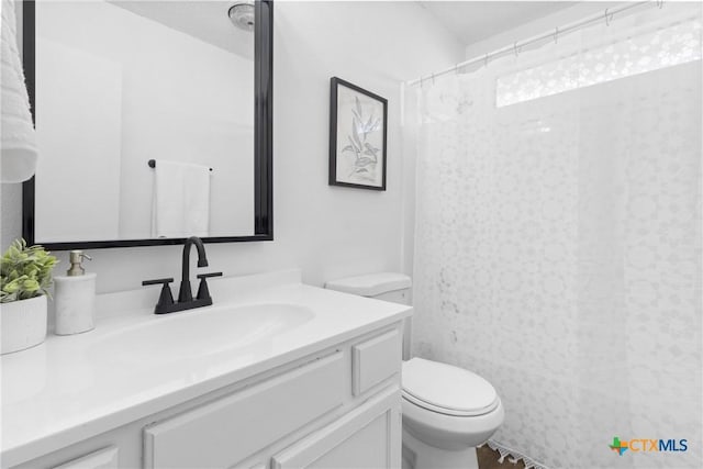 bathroom with vanity, toilet, and curtained shower