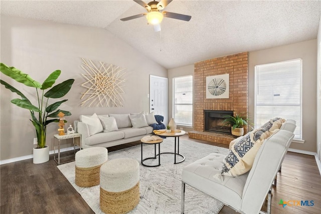 living room with vaulted ceiling, a textured ceiling, dark hardwood / wood-style flooring, and a fireplace