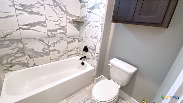 bathroom with toilet, tile walls, and  shower combination