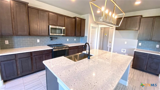 kitchen with tasteful backsplash, light stone countertops, sink, and stainless steel appliances