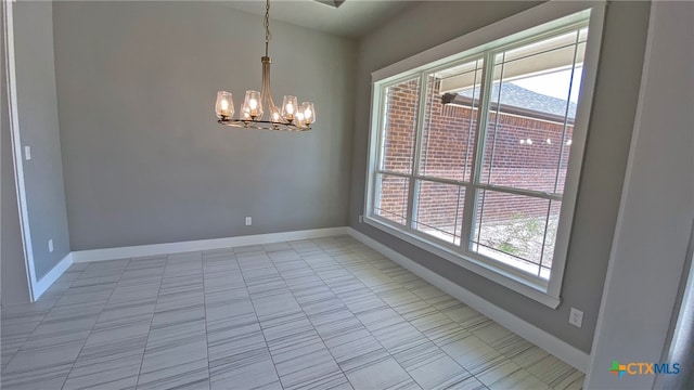 empty room with a chandelier and light tile patterned floors