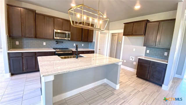 kitchen with pendant lighting, appliances with stainless steel finishes, sink, and tasteful backsplash