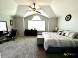 carpeted bedroom with lofted ceiling and ceiling fan