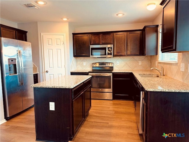 3413 Malmaison Rd, Killeen, TX 76542 - kitchen featuring appliances with stainless steel finishes, a sink, light wood-style floors, dark brown cabinets, and recessed lighting