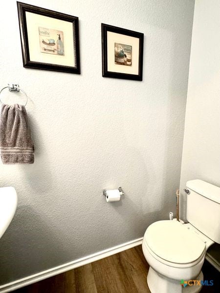 bathroom with toilet and hardwood / wood-style flooring