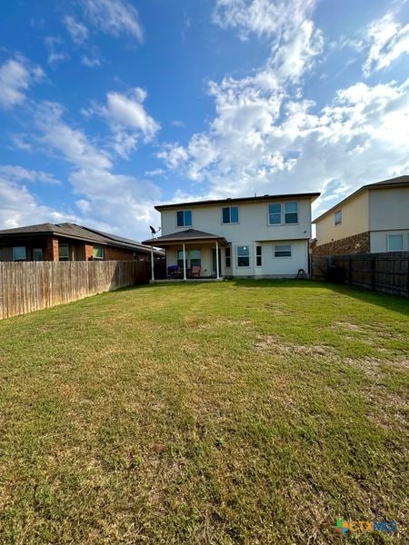 rear view of property featuring a lawn