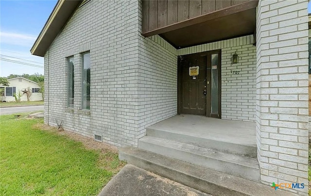 entrance to property featuring a yard