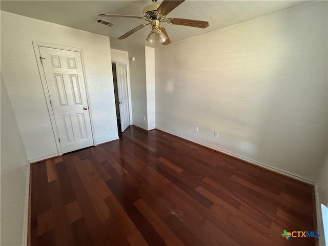 unfurnished bedroom featuring ceiling fan and dark hardwood / wood-style flooring