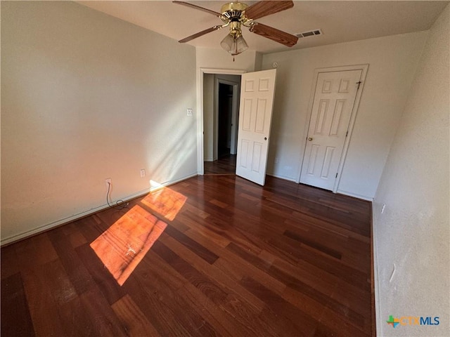 unfurnished room with ceiling fan and dark hardwood / wood-style flooring