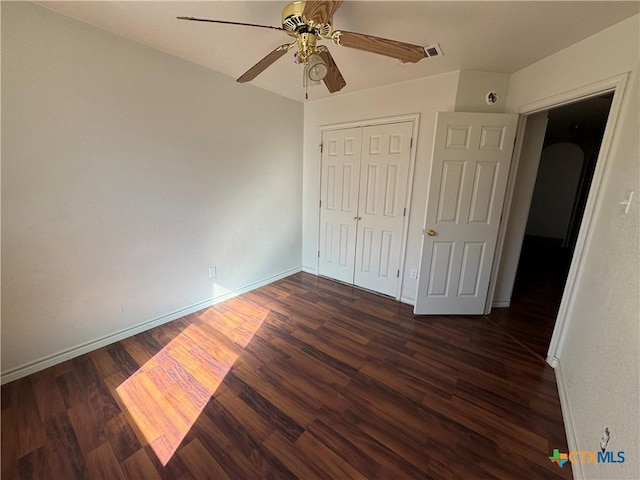 unfurnished bedroom featuring ceiling fan, dark hardwood / wood-style flooring, and a closet