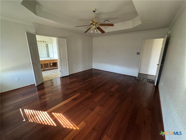 unfurnished room featuring a raised ceiling, crown molding, ceiling fan, and dark hardwood / wood-style floors