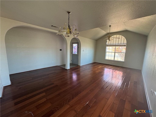 spare room with a textured ceiling, ceiling fan with notable chandelier, vaulted ceiling, and dark wood-type flooring