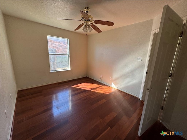 empty room featuring a textured ceiling, ceiling fan, and dark hardwood / wood-style floors