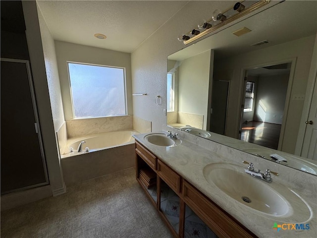 bathroom with wood-type flooring, vanity, a textured ceiling, and a bathtub