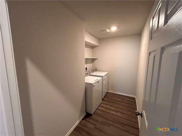 clothes washing area with washer and dryer and dark wood-type flooring