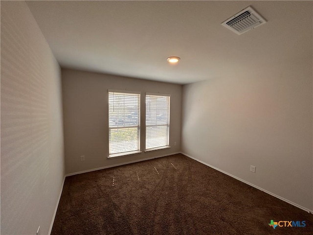 unfurnished room with dark carpet