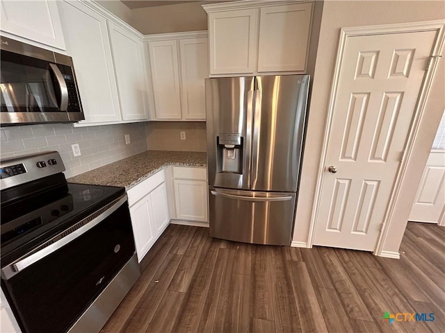 kitchen with backsplash, dark wood-type flooring, white cabinets, light stone countertops, and stainless steel appliances