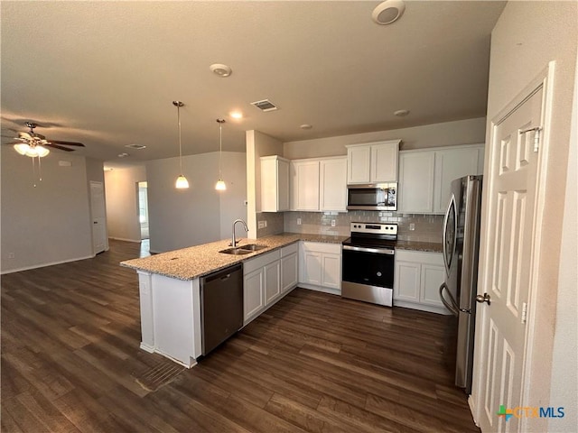 kitchen featuring white cabinetry, dark hardwood / wood-style flooring, hanging light fixtures, and appliances with stainless steel finishes