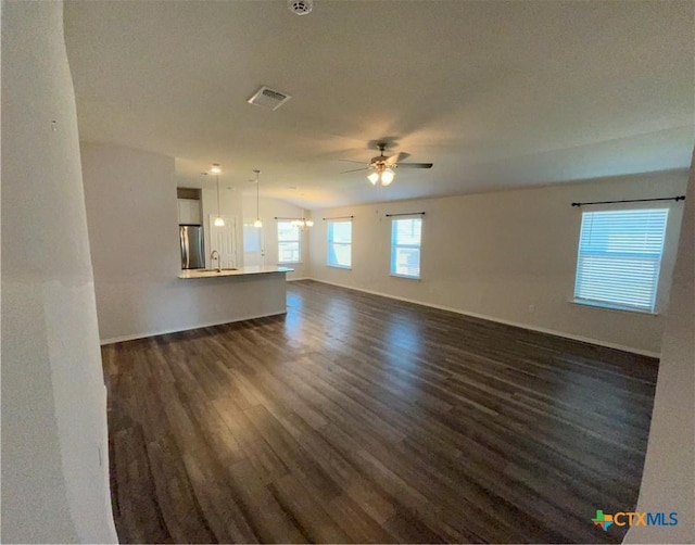 unfurnished living room with ceiling fan, sink, dark wood-type flooring, and a textured ceiling